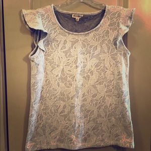 Women’s gray and white flower shirt with ruffles.